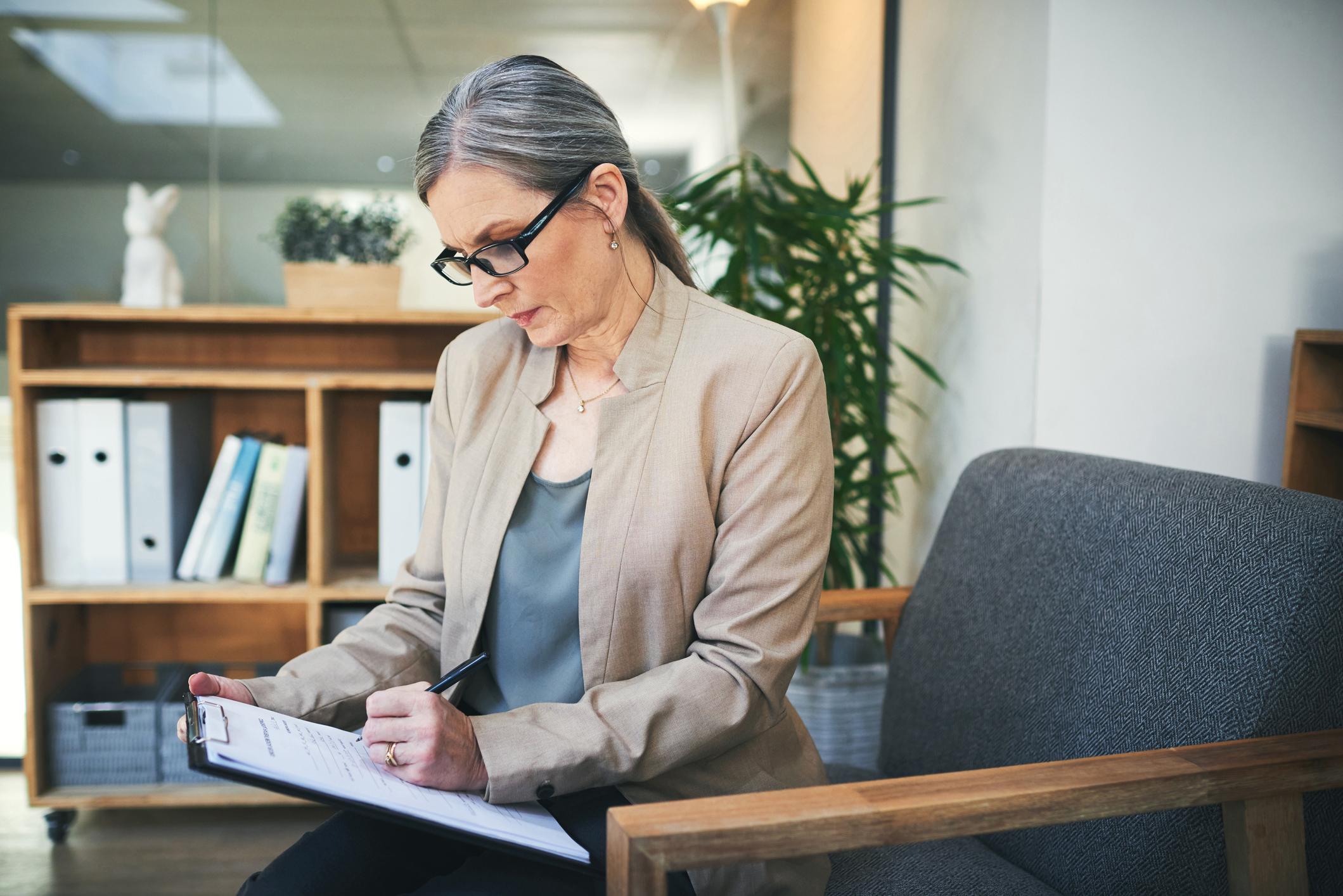 woman writing notes on a notepad